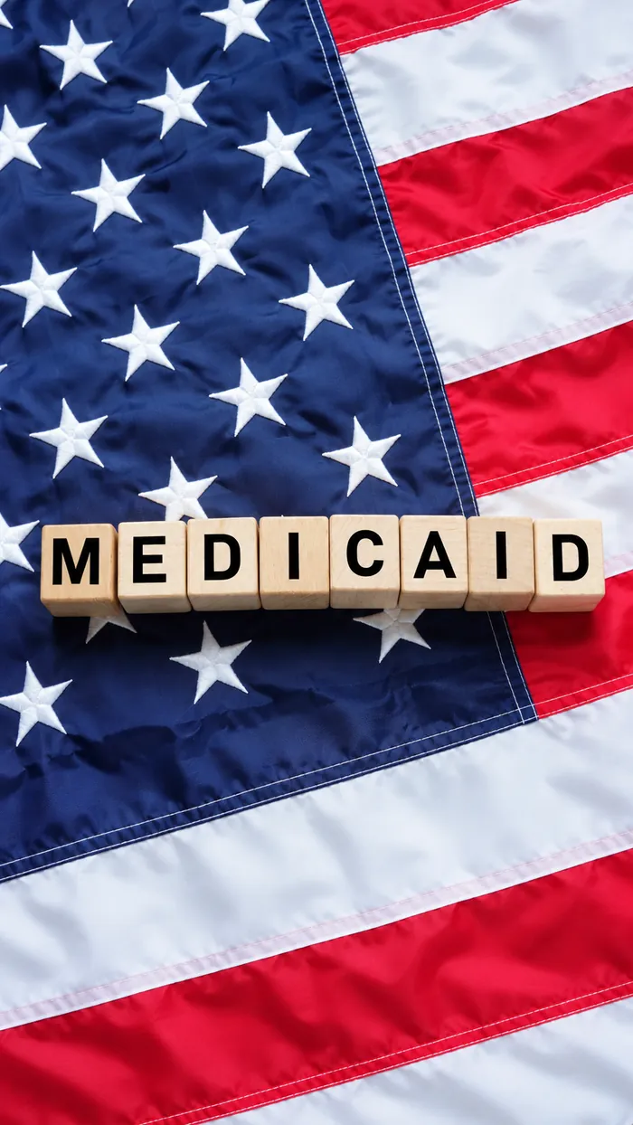Bloques de madera con la palabra Medicaid sobre la bandera de Estados Unidos